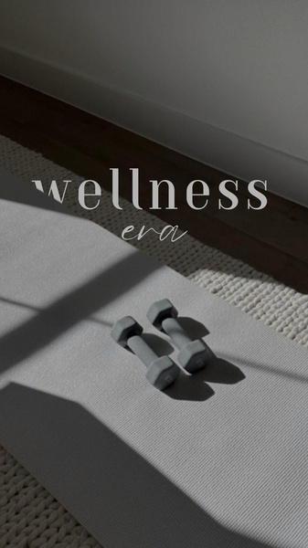 A high-angle, moody shot of two gray dumbbells resting on a textured workout mat, featuring elegant typography overlay.